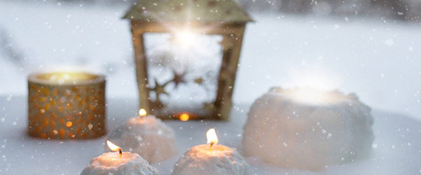 Kynttilöitä ja lyhtyjä lumella.