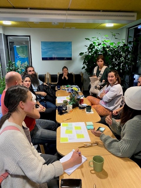 Pöydän ääressä työpajaan osallistuvia henkilöitä.